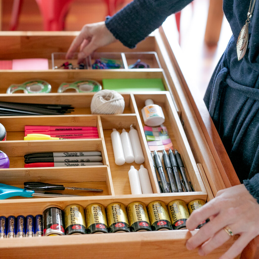A clean and organized drawer with office supplies intentionally placed in drawer organizers