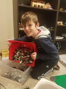 A young boy, Nathan, organizing his Lego collection with the help of ReSPACEd Professional Organizing in Portland